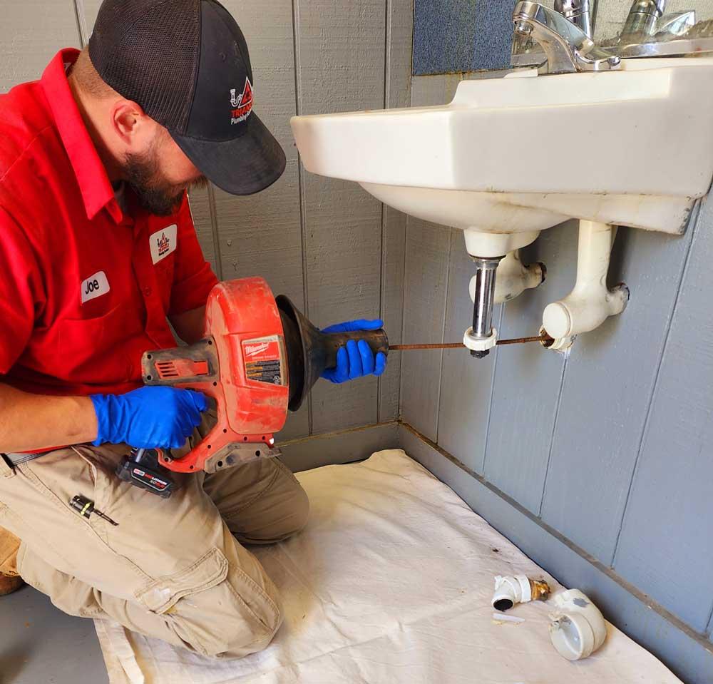 Installateur behebt ein Problem unter einem Waschbecken